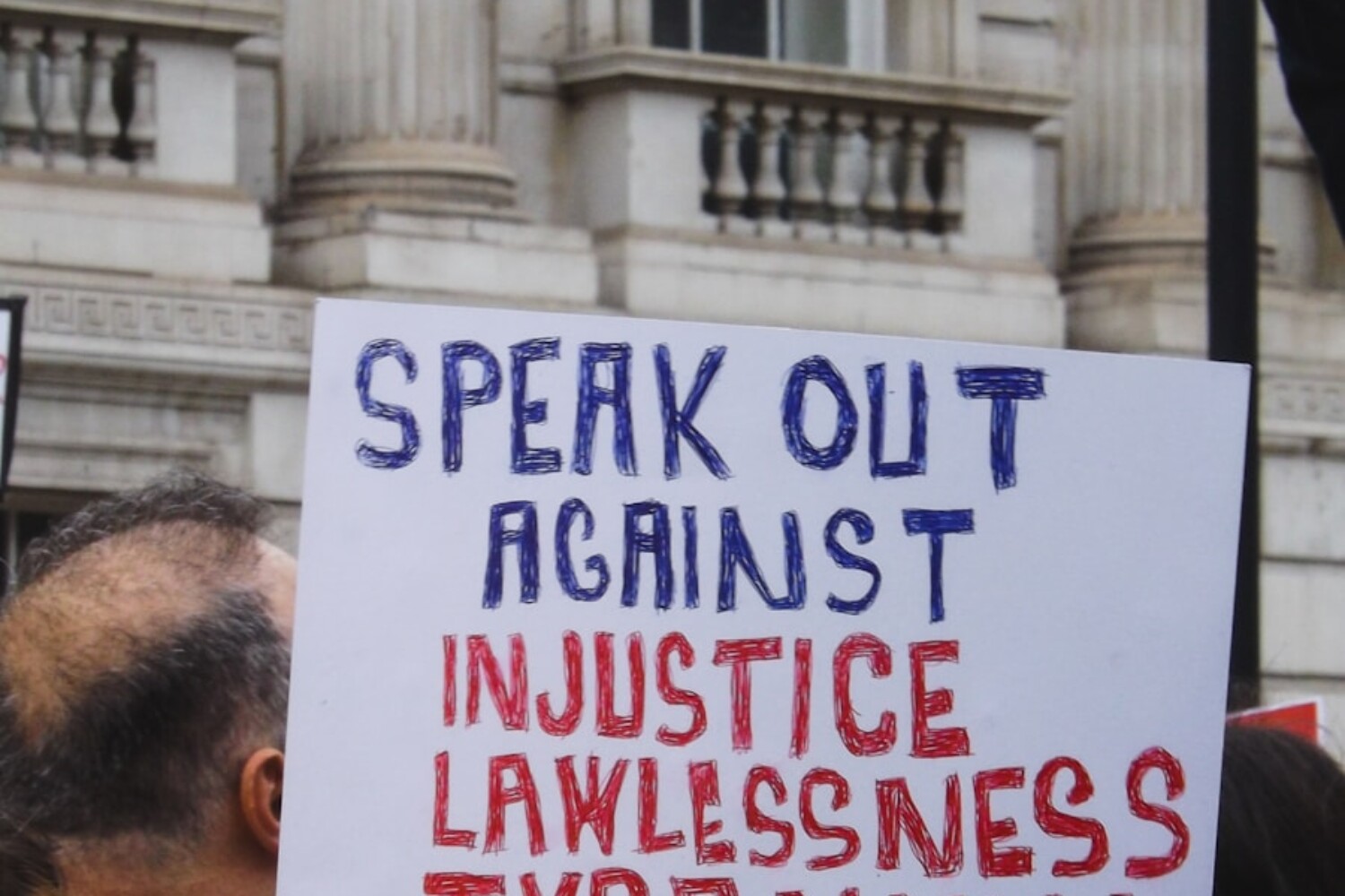 Protester holds a sign against injustice and tyranny.