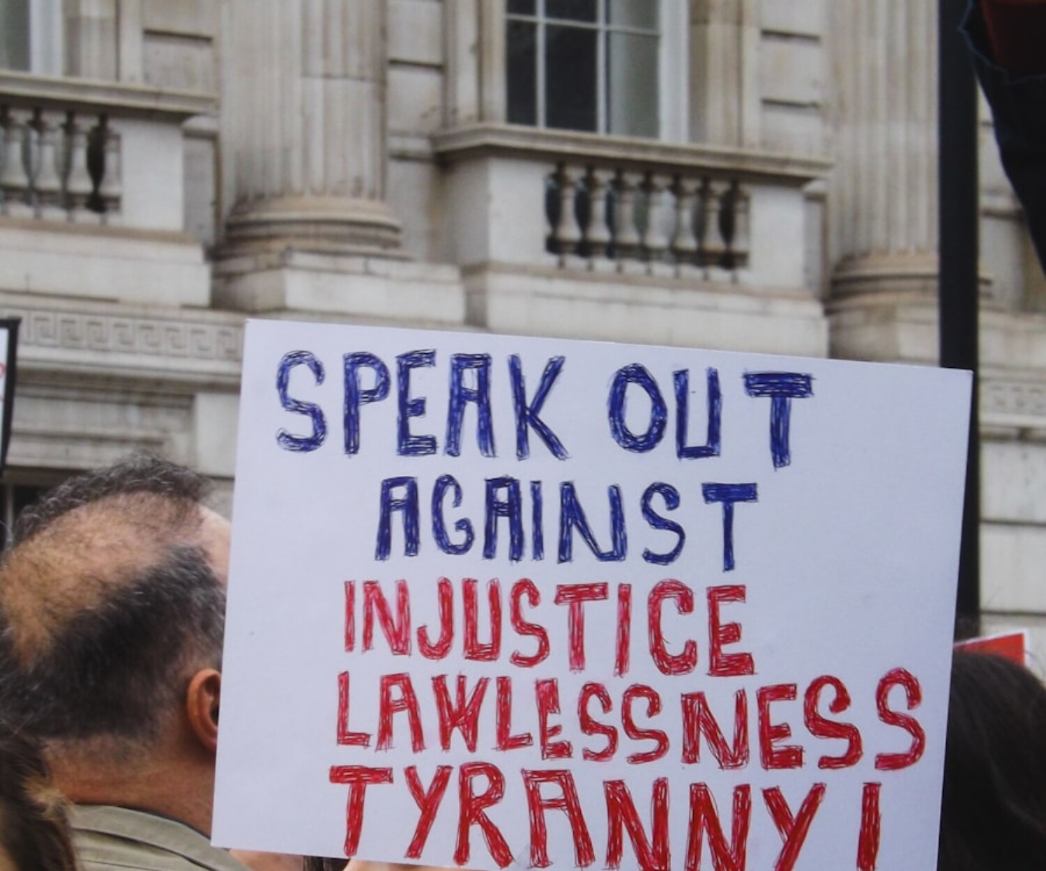 Protester holds a sign against injustice and tyranny.